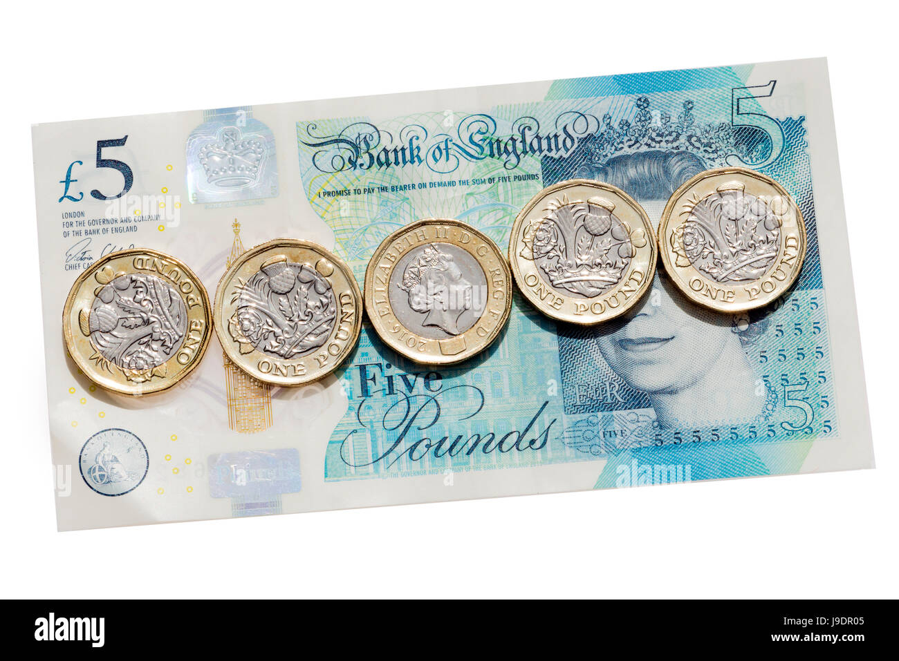 Neue Pfund-Münzen auf eine fünf-Pfund-Note, Ausschneiden oder isoliert auf einem weißen Hintergrund. Stockfoto