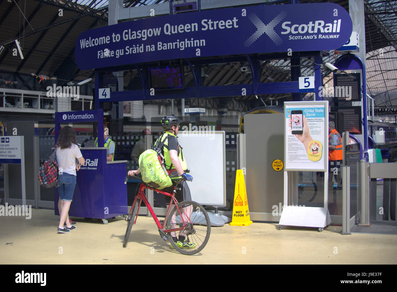 Radfahrer an der Queen street Station Eisenbahn unter dem gälischen Zeichen scotrail Stockfoto