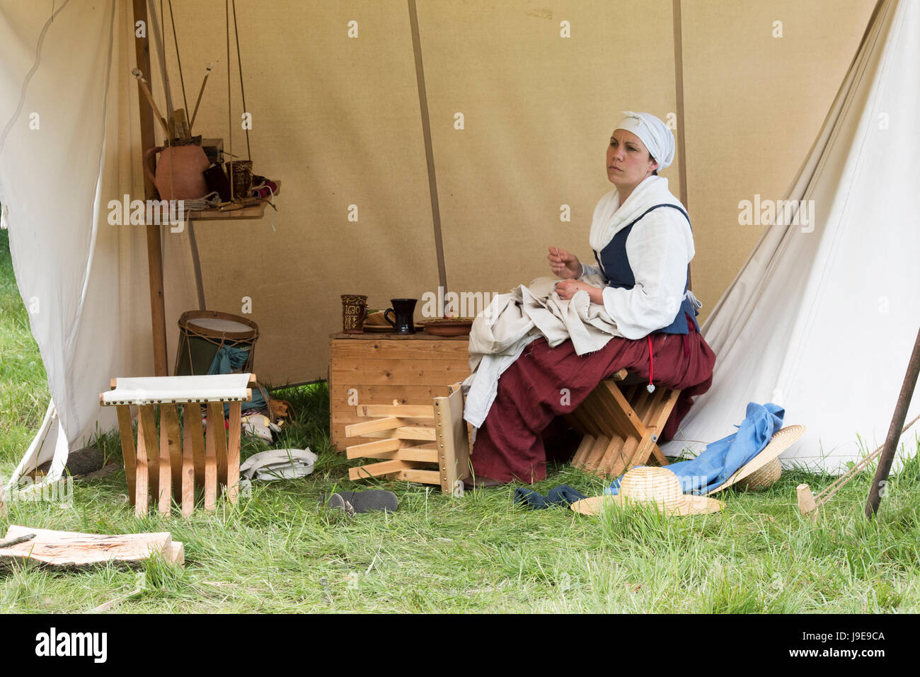 Frau Nähen ein Hemd in ein Lager bei einem Sealed Knot englischen Civil War Reenactment Event.  Charlton Park, Malmesbury, Wiltshire, UK Stockfoto