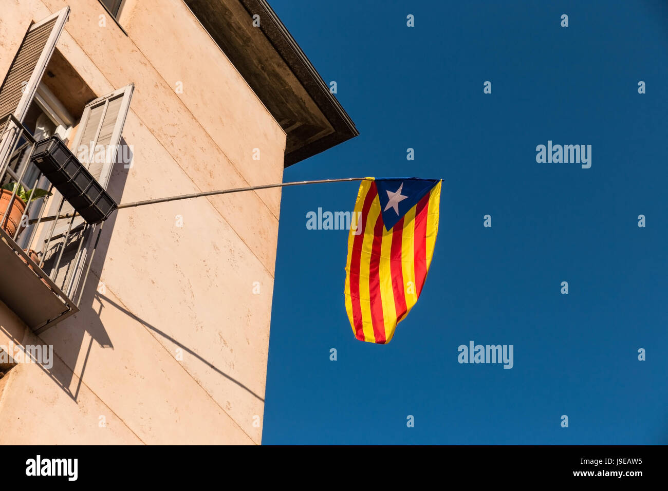 Flagge der Unabhängigkeitsbewegung von Katalonien, genannt Estelada (inoffiziell), in einer Straße in der Innenstadt von Girona, Costa Brava, Katalonien, Spanien. Stockfoto