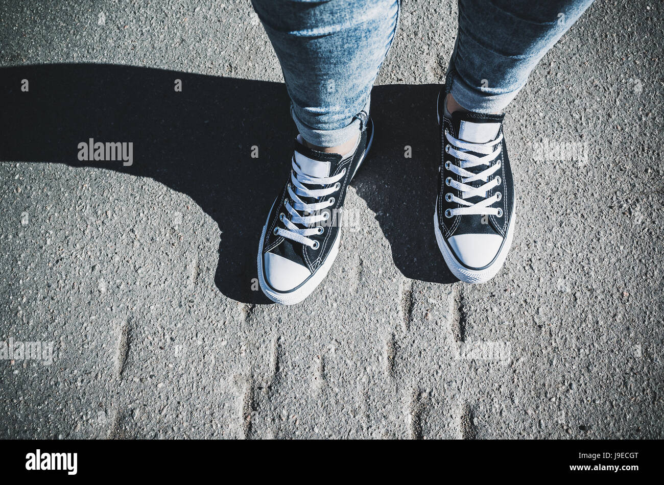 Schwarz / weiß neue Turnschuhe, Teenager Füße auf städtischen Bürgersteig stehen Stockfoto