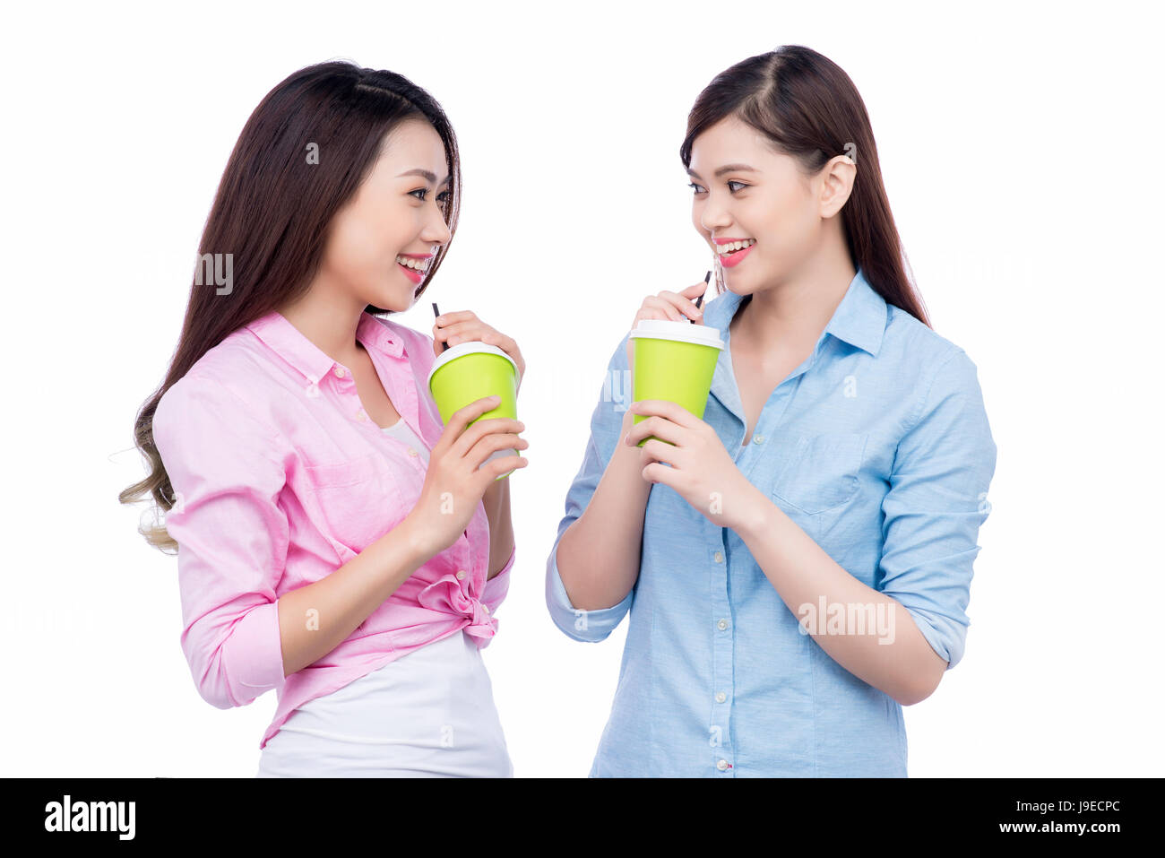 Fröhliche asiatischen Freundinnen Kaffeebecher genießen ein Gespräch halten Stockfoto