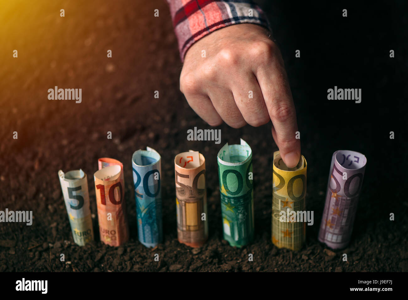 Euro Geld, landwirtschaftliche Konzeptbild mit der Hand pflücken EU Geldschein aus fruchtbarem Boden Boden ernten Stockfoto