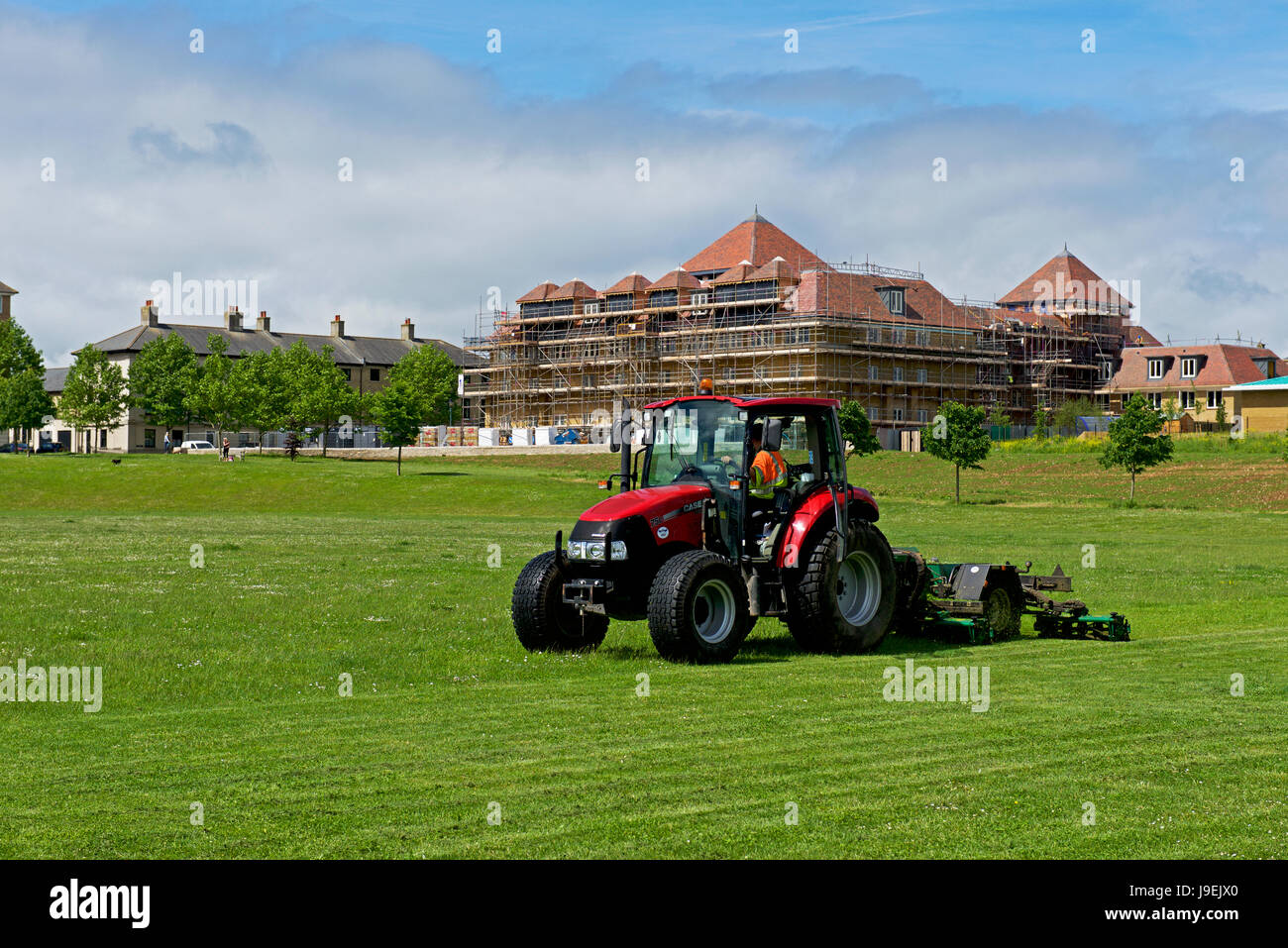 Traktor mit Bande Mäher am Spielfeld, Verkehrssysteme, Dorset, England UK Stockfoto