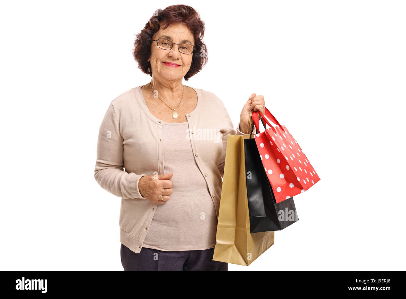 Ältere Frau mit Einkaufstüten, schaut in die Kamera, die isoliert auf weißem Hintergrund Stockfoto