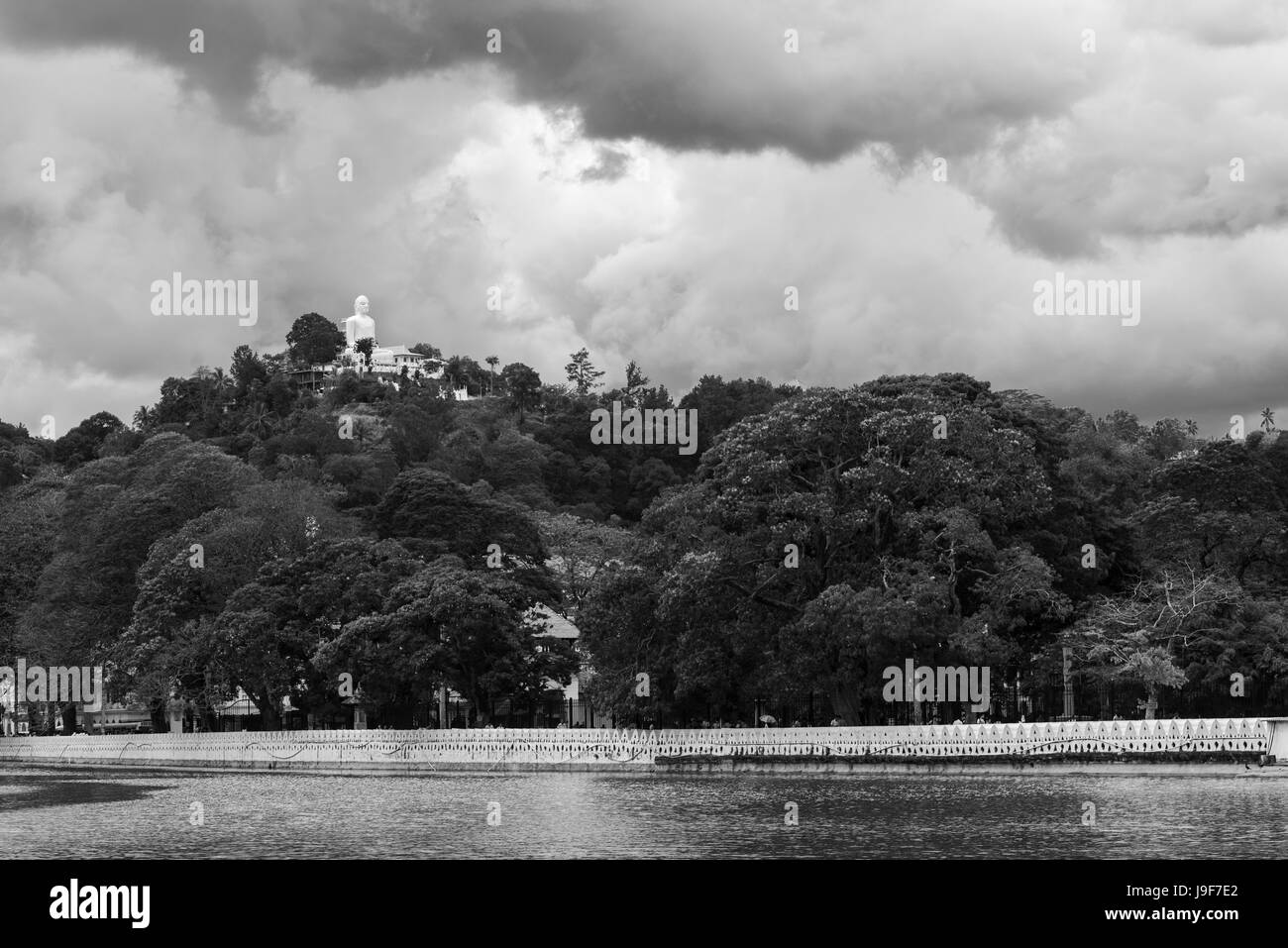 Eine riesige Statue des Buddha sitzt auf einem Hügel mit Blick auf den See in Kandy, Sri Lanka Stockfoto