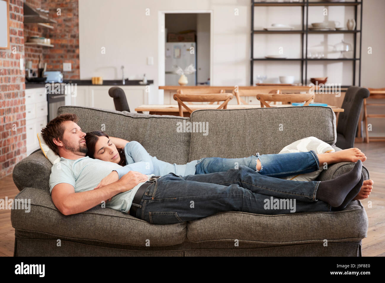 Paar ruht auf Sofa In offene Lounge Stockfoto