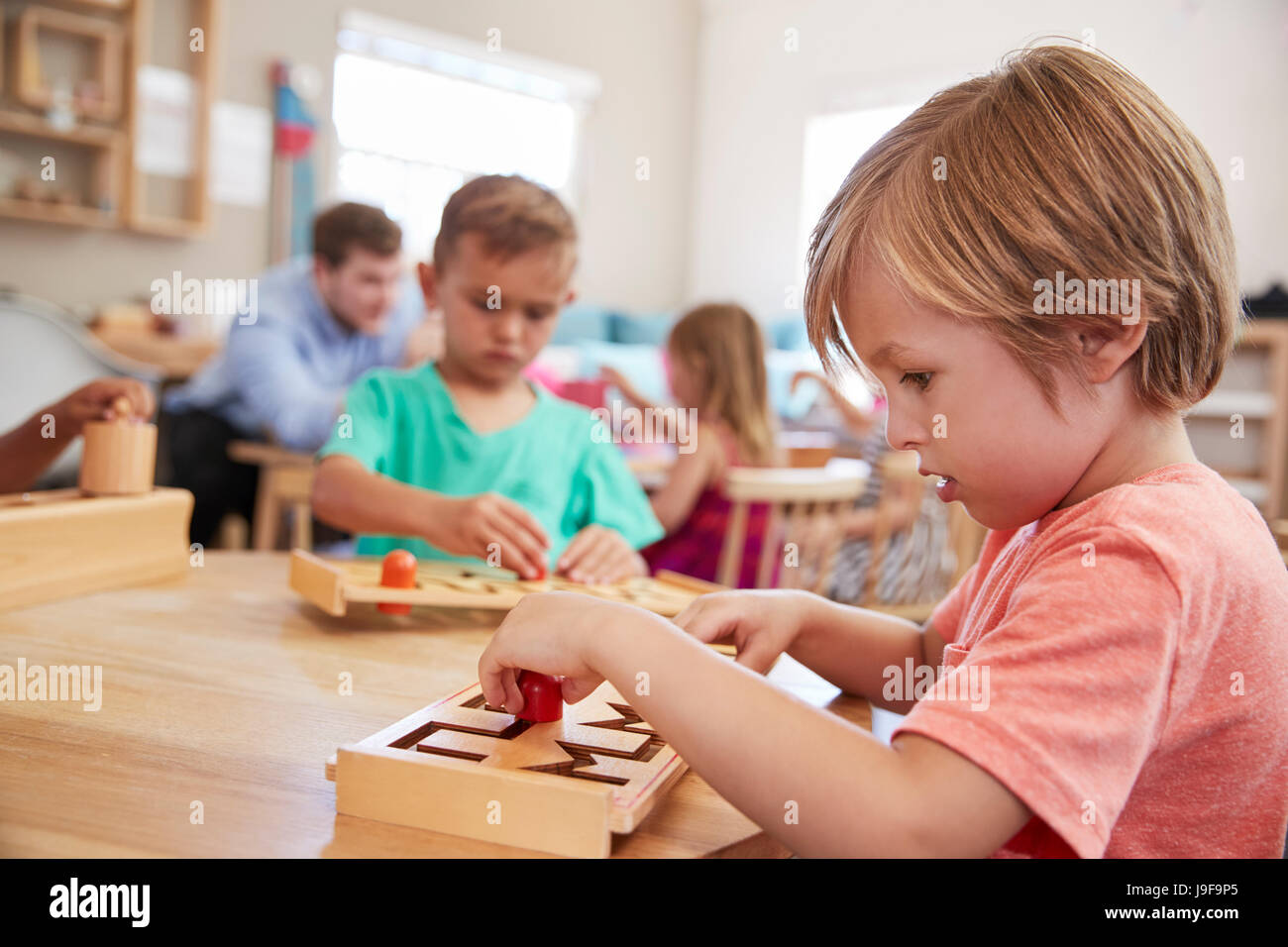 Weibliche Schüler arbeiten am Tisch In der Montessori-Schule Stockfoto