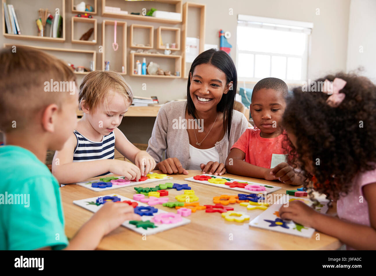 Lehrer und Schüler mit Blütenformen In Montessori-Schule Stockfoto