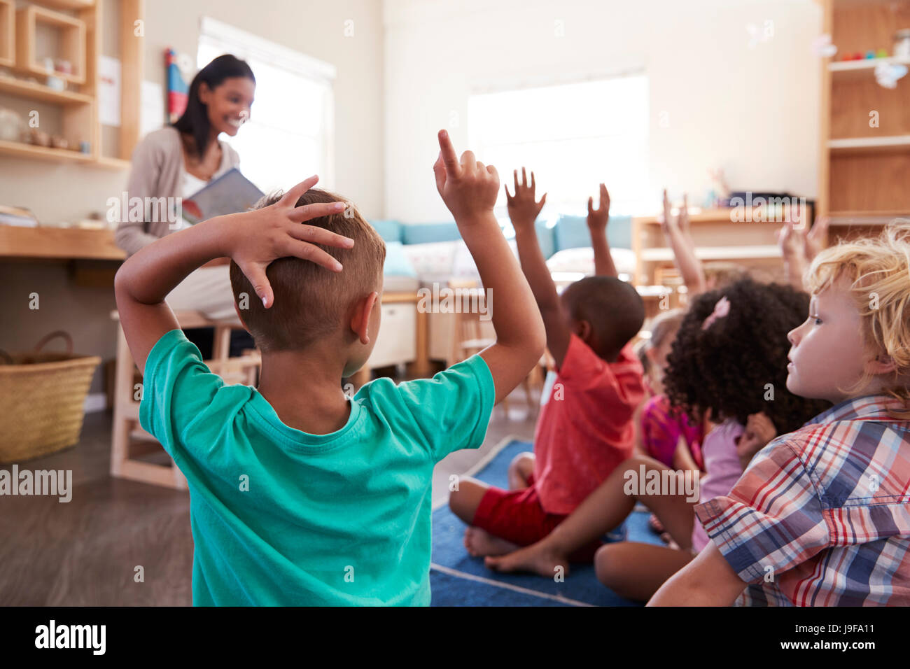 Schülerinnen und Schüler in der Montessori Schule Erziehung Hände um die Frage zu beantworten Stockfoto