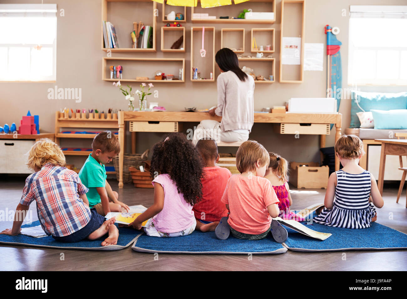 Kinder im Montessori Schule lesen selbständig im Klassenzimmer Stockfoto