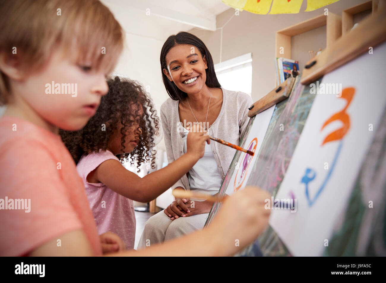 Lehrer an der Montessori-Schule Kinderhilfe im Kunstunterricht Stockfoto