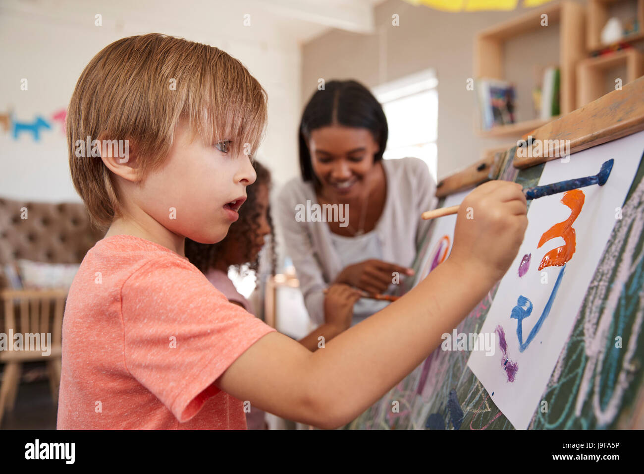 Lehrer an der Montessori-Schule Kinderhilfe im Kunstunterricht Stockfoto