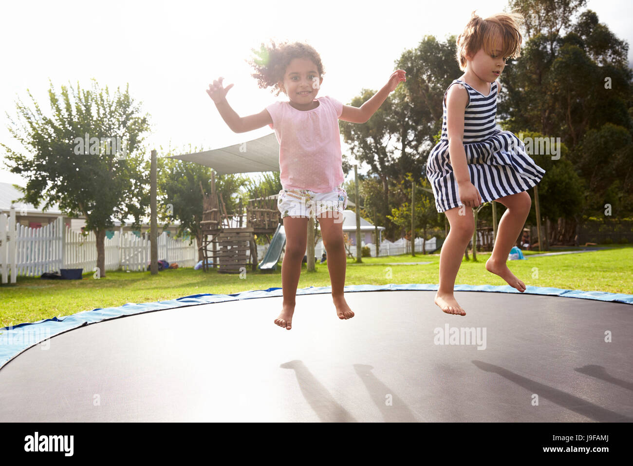 Kinder in der Montessori Schule Spaß am Outdoor-Trampolin Stockfoto