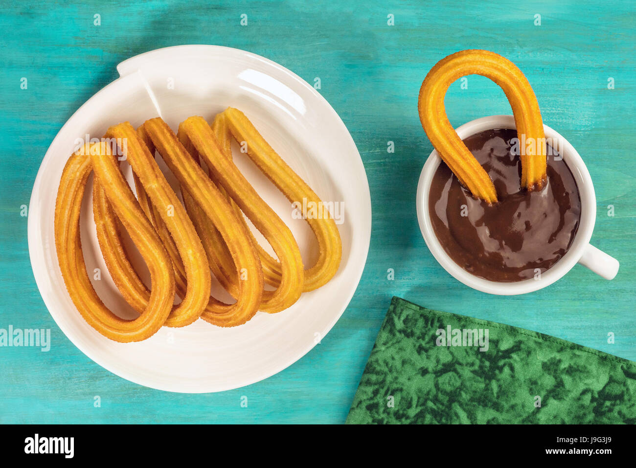 Eine Platte von Churros, traditionelle spanische vor allem Madrid, Dessert, besonders für Sonntagsfrühstück mit einer Tasse heißer Schokolade, geschossen von oben o Stockfoto