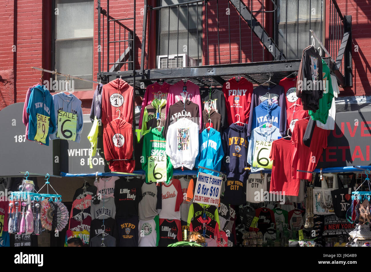 Kleidung zum Verkauf aufhängen außerhalb einer Little Italy-Souvenir-Shop in New York City Stockfoto