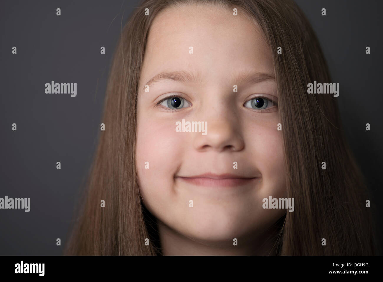 lächelnde Mädchen Gesicht Porträt auf grauem Hintergrund Stockfoto