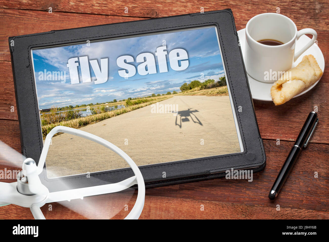 Fliegen Sie sicher Konzept oder Erinnerungs - Luftbild auf einem digitalen Tablet mit einer Drohne Propeller und Kaffee Stockfoto Fliegen Sie sicher Konzept oder Erinnerungs - Luftbild auf einem digitalen Tablet mit einer Drohne Propeller und Kaffee Stockfoto