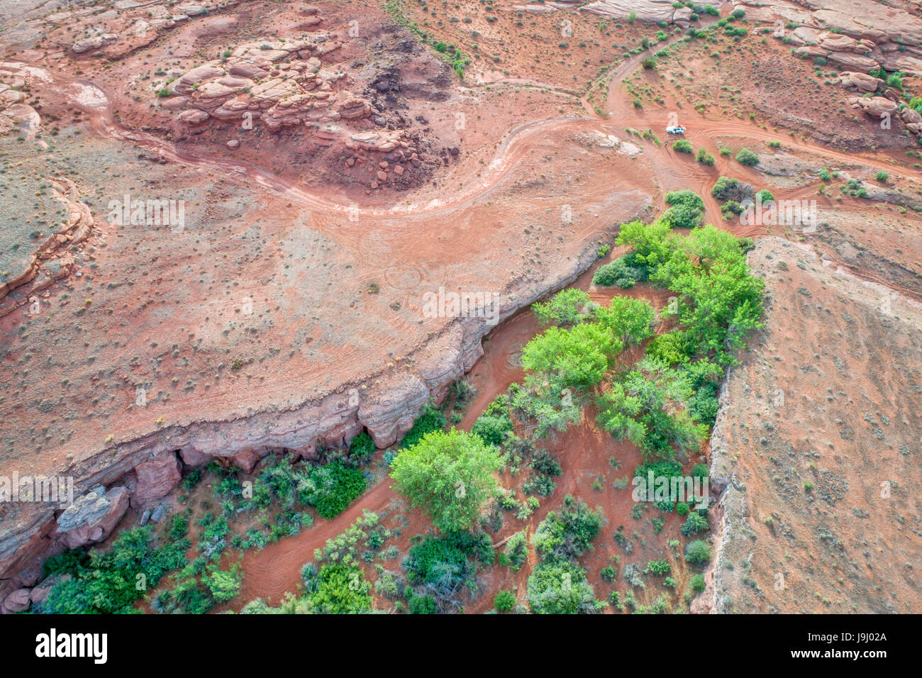 Luftaufnahme von einer Wüste in der Gegend Moab, Utah, mit Canyon, Jeep Trail und SUV Stockfoto