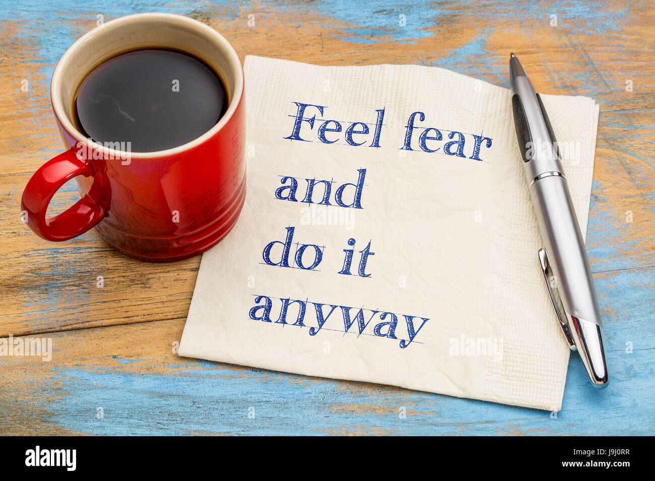 Das Gefühl Angst und tun es trotzdem - motivierende Handschrift auf einer Serviette mit einer Tasse Kaffee Stockfoto