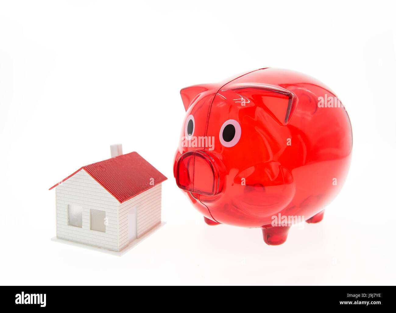 Sparschwein und ein Haus auf weißem Hintergrund Stockfoto