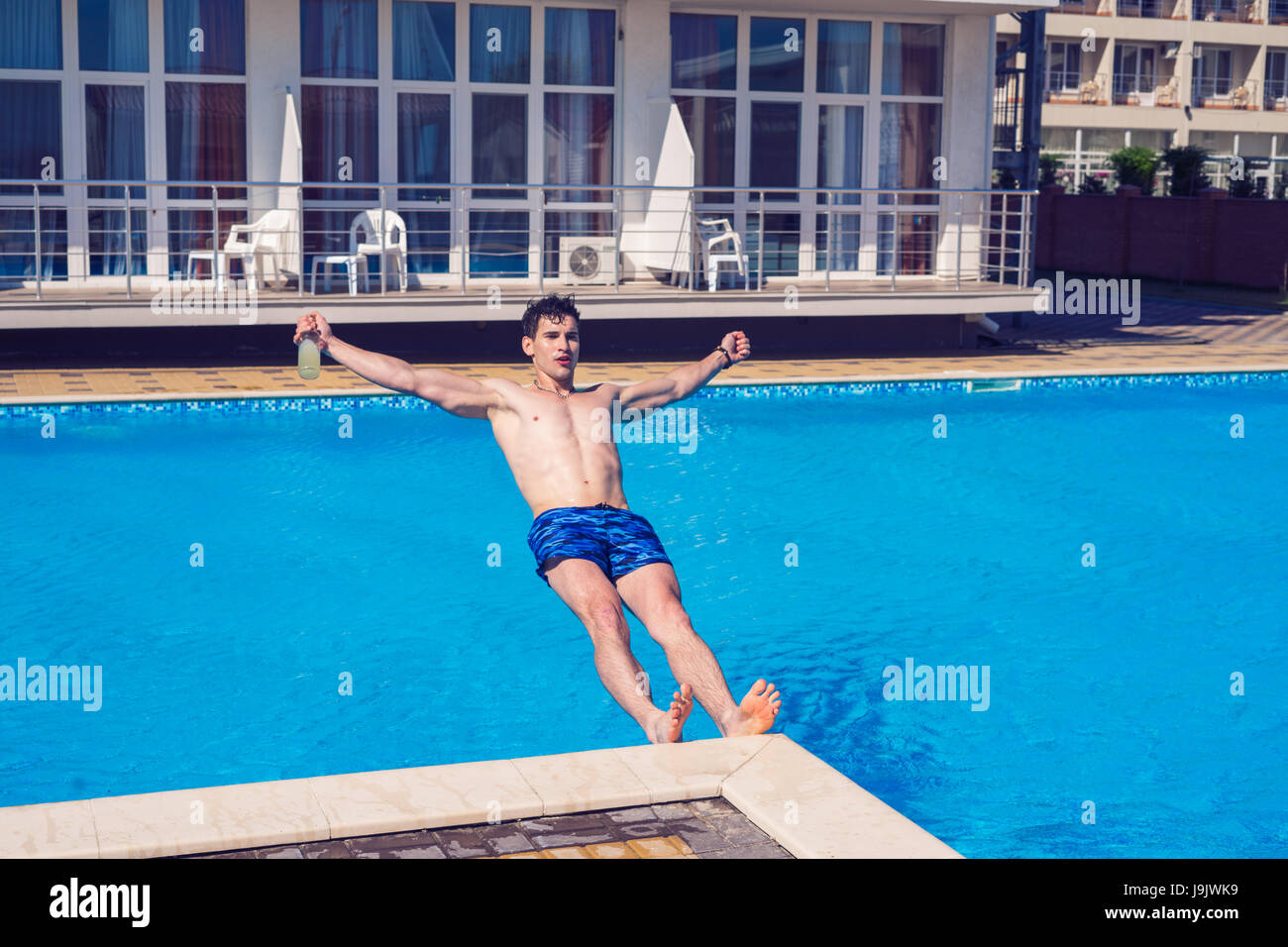 Betrunkener Mann fallen ins Wasser mit Bier in der hand Stockfoto