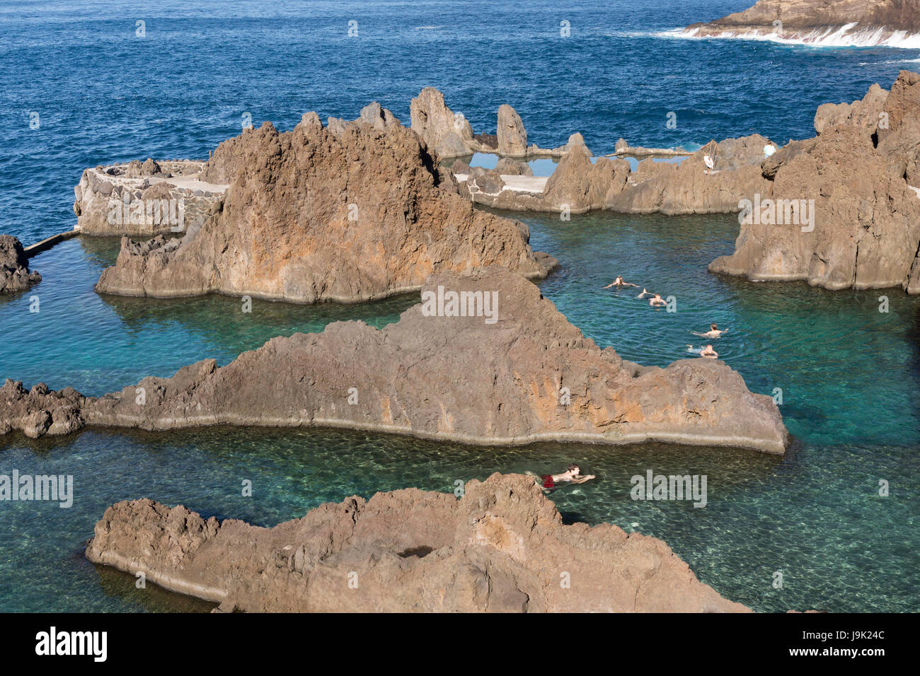 Menschen schwimmen in natürlichen Fels-Pools - Piscinas Verwaltungsbehörde - bei Porto Moniz, Madeira Stockfoto