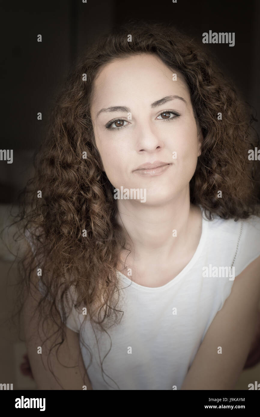 Porträt einer Frau von 31 Jahre alten Kamera in eine selbstbewusste Weise suchen, lockig und lange Haare, Kaukasier, Griechisch. Stockfoto
