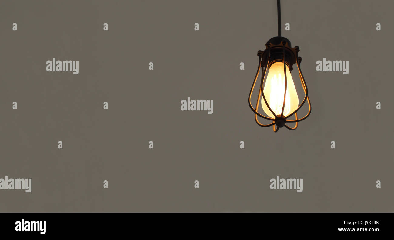 Beleuchtete hängenden Glühbirnen auf grauen einfarbigen Hintergrund mit Freitext Raum isoliert Stockfoto