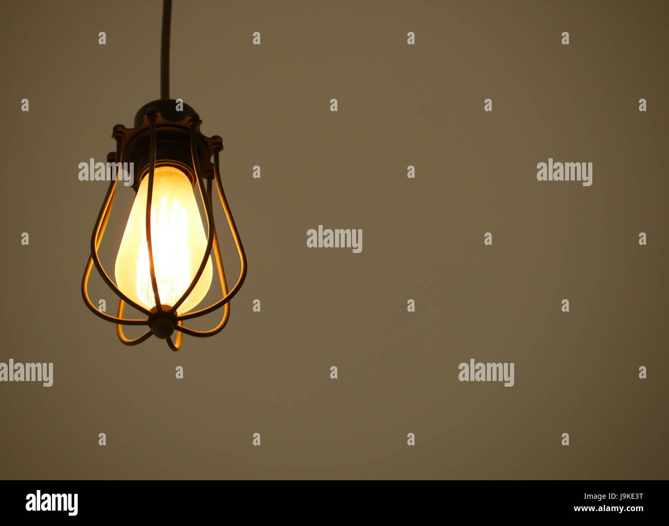 Gelb beleuchtete hängenden Glühbirnen auf braune einfarbigen Hintergrund mit Freitext-Raum Stockfoto