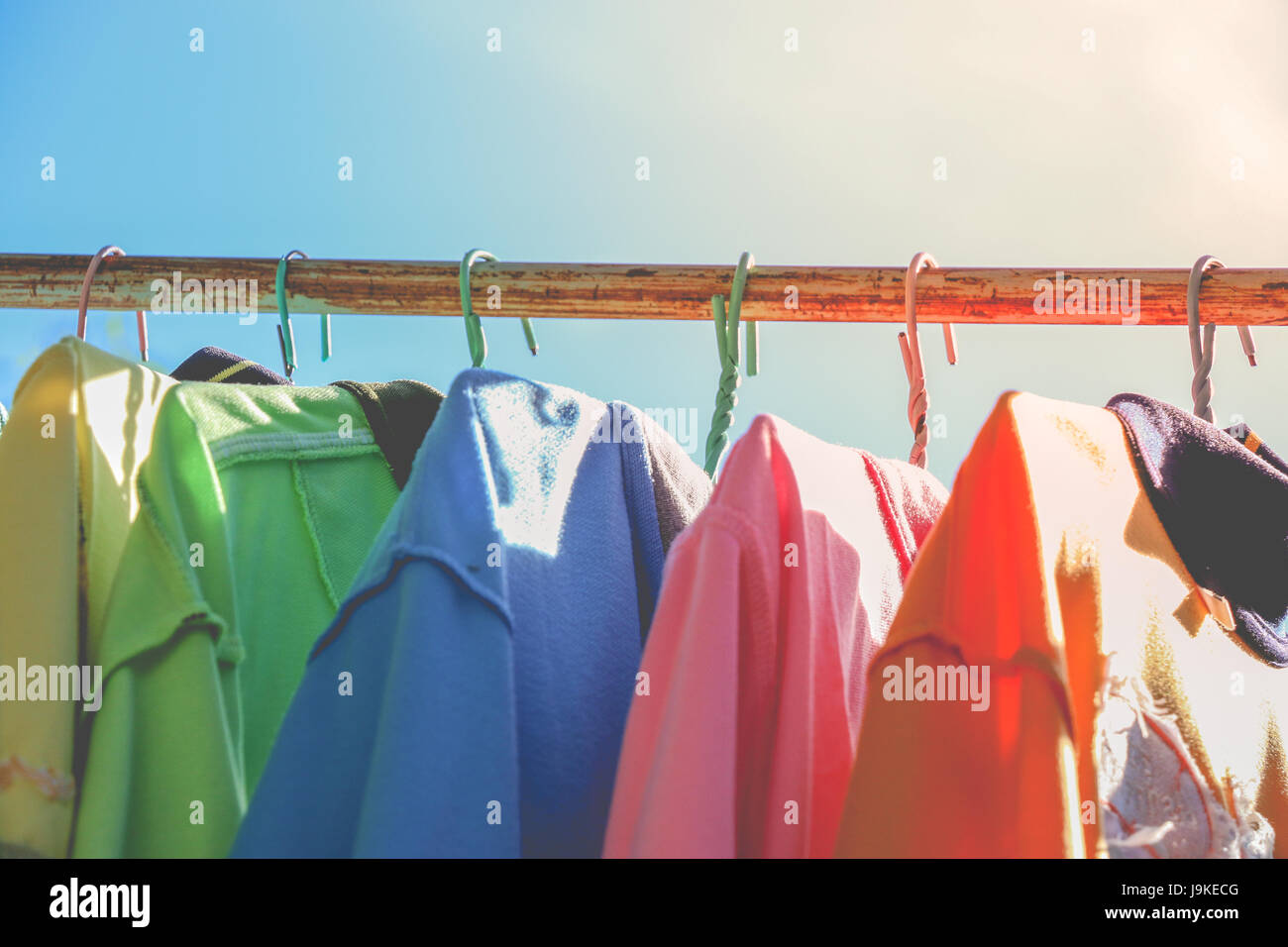 Trockene Tücher und T-Shirt, an sonnigen Tagen auf der Wäscheleine hängen. buntes T-shirt. Stockfoto