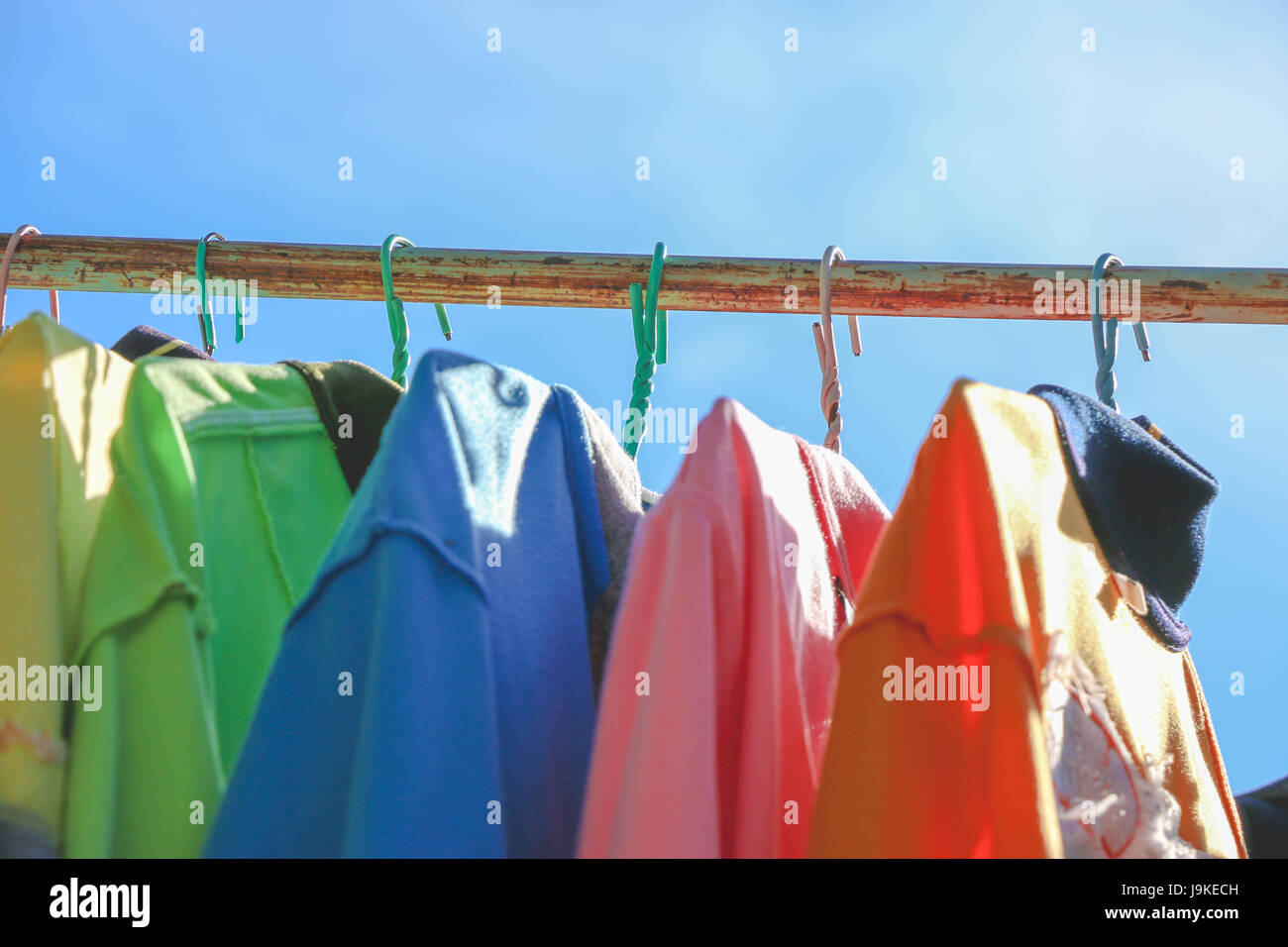 Trockene Tücher und T-Shirt, an sonnigen Tagen auf der Wäscheleine hängen. buntes T-shirt. Stockfoto