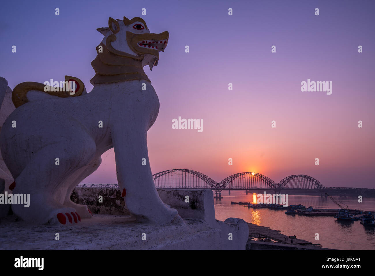 Löwen-Statue in der Nähe von Yadanarbon Brücke bei Sonnenuntergang über Ayeyarwady Fluss, moderne Brücke in Mandalay-Division, Burma Stockfoto
