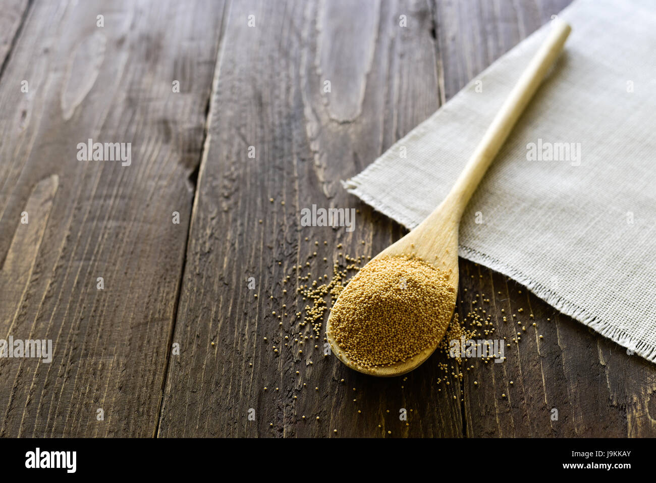 Kochlöffel mit rohen Amarantsamen auf hölzernen Hintergrund Stockfoto