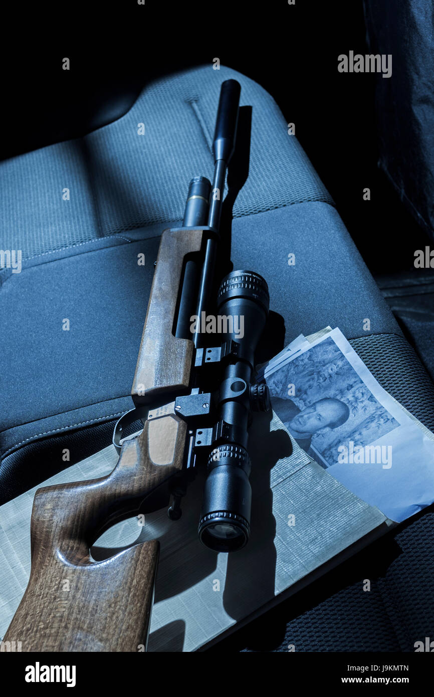 Eine Pistole und Fotos auf dem Rücksitz eines Autos. Stockfoto