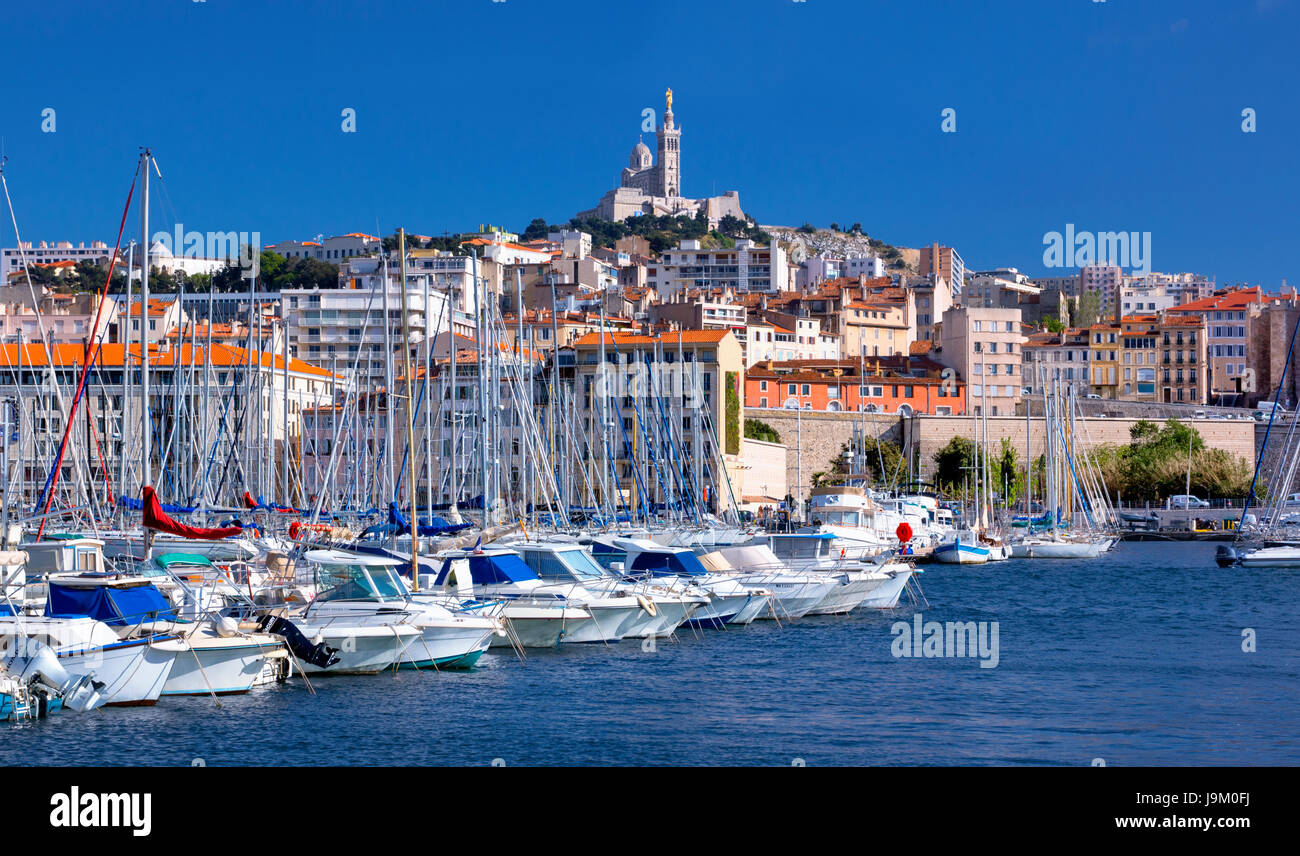 Boote in der Marina von Vieux-Port mit Notre Dame De La Garde in Marseille Hintergrund Stockfoto