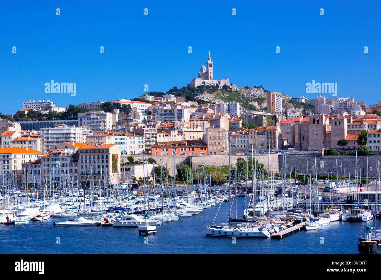 Boote in der Marina von Vieux-Port, alten Hafen, mit Notre Dame De La Garde in Marseille Hintergrund Stockfoto