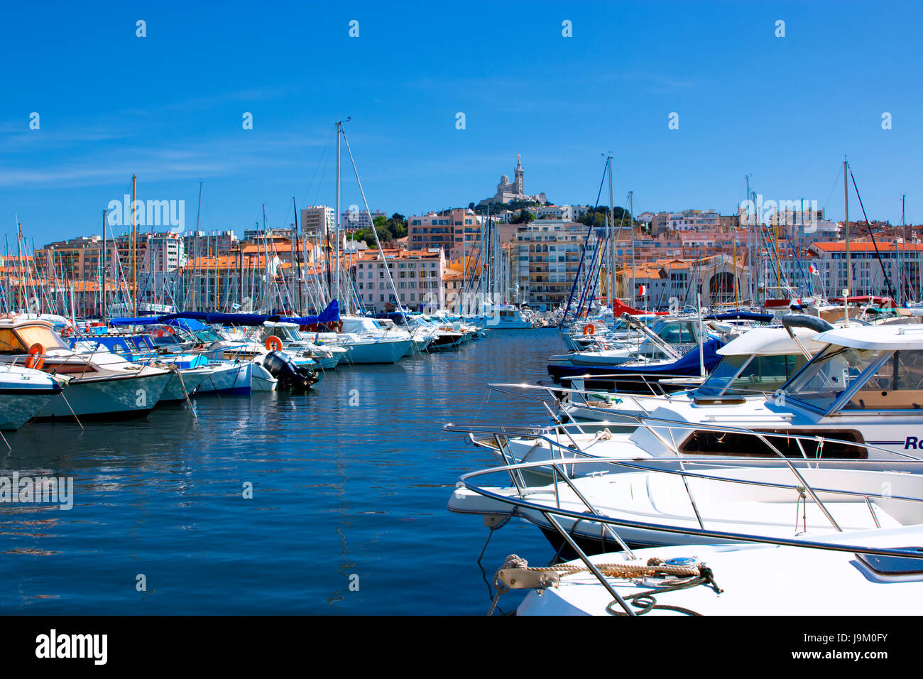 Boote in der Marina von Vieux-Port, alten Hafen, mit Notre Dame De La Garde in Marseille Hintergrund Stockfoto