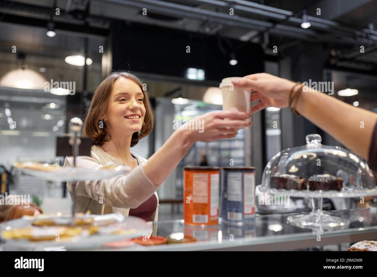 glückliche Frau, die Kaffeetasse vom Verkäufer im café Stockfoto