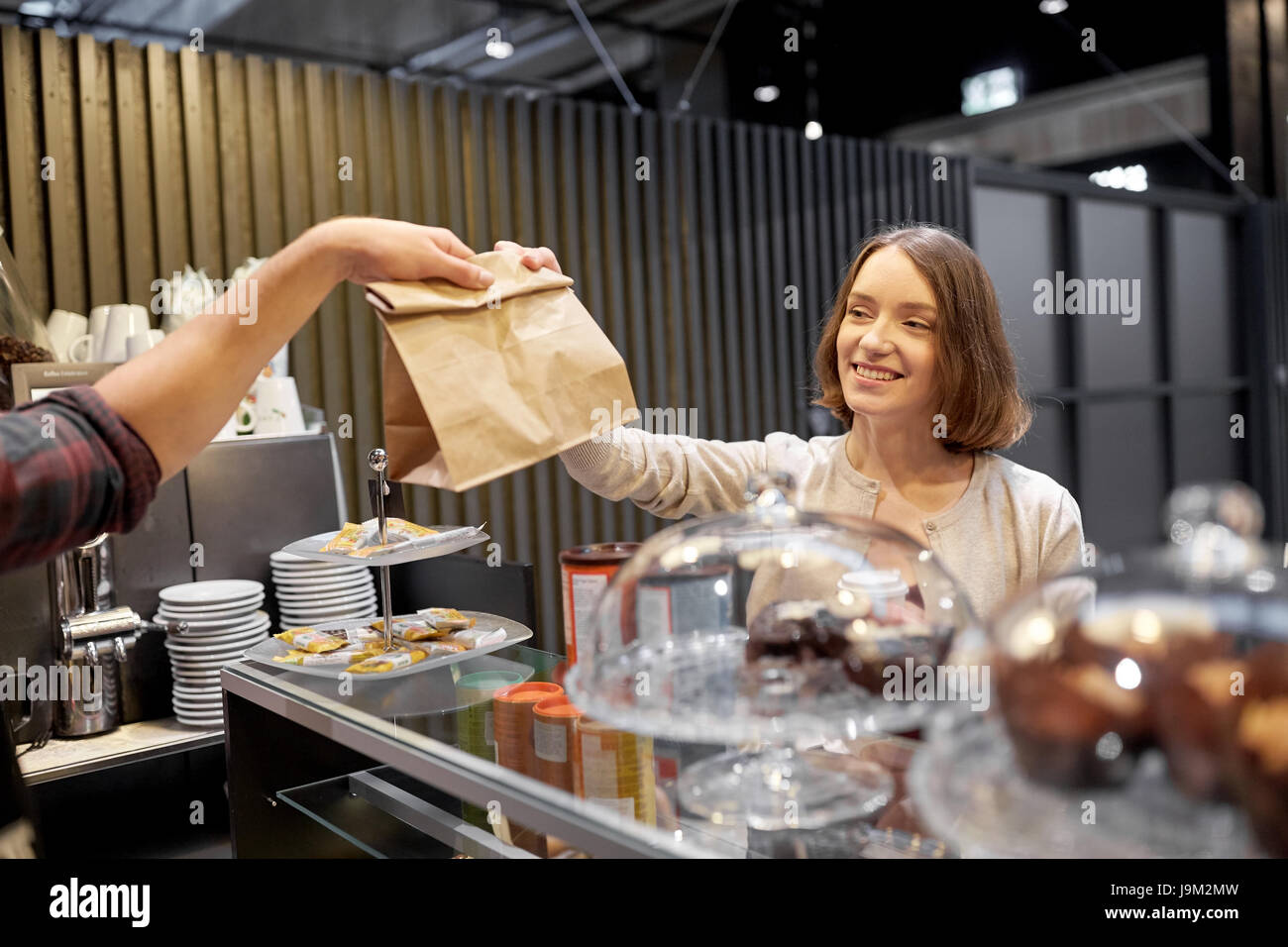 Frau, die Papiertüte vom Verkäufer im café Stockfoto
