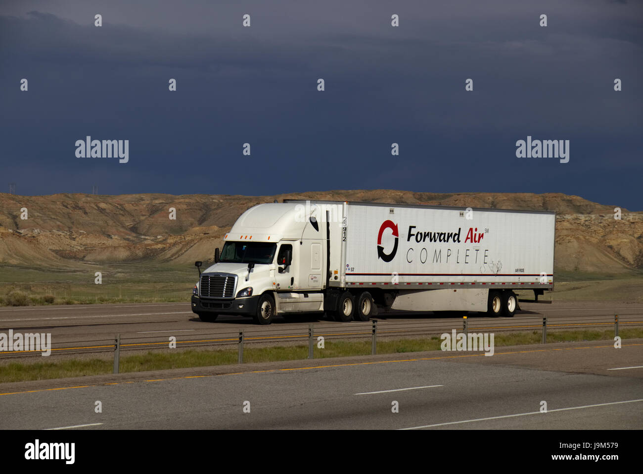 Ein White Freightliner Semi-Truck zieht einen weißen "nach vorne Luft komplett" entlang einer ländlichen uns Interstate Trailer. Stockfoto