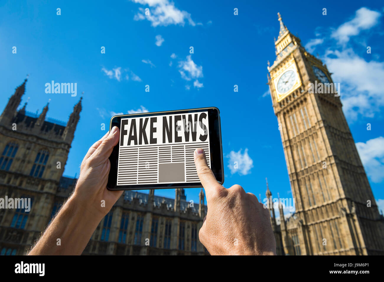 Reader Scrollen durch gefälschte Nachrichten Geschichten auf seinem Tablettcomputer vor den Houses of Parliament, Westminster Palace in London, England Stockfoto