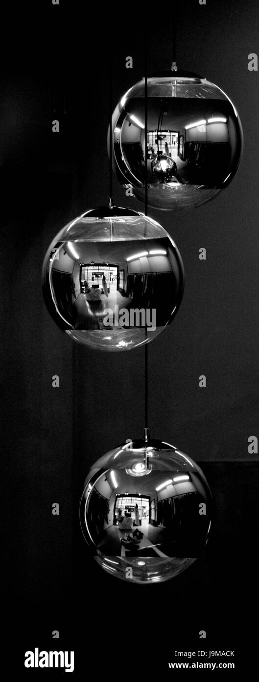 Reflexionen in einem dreifachen hängende Lampenschirme aus Metall Stockfoto