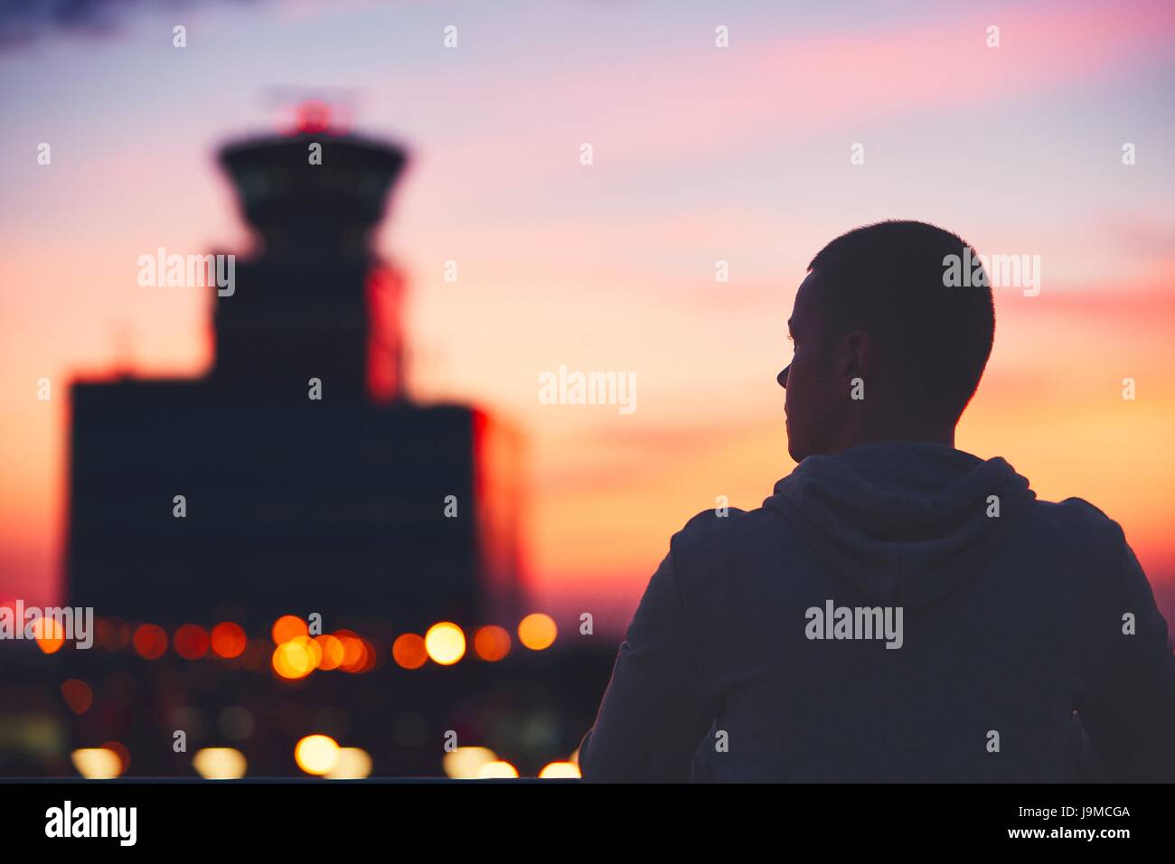 Silhouette des Reisenden am Flughafen. Air Traffic Control Tower in den traumhaften Sonnenuntergang. Prag, Tschechische Republik. Stockfoto