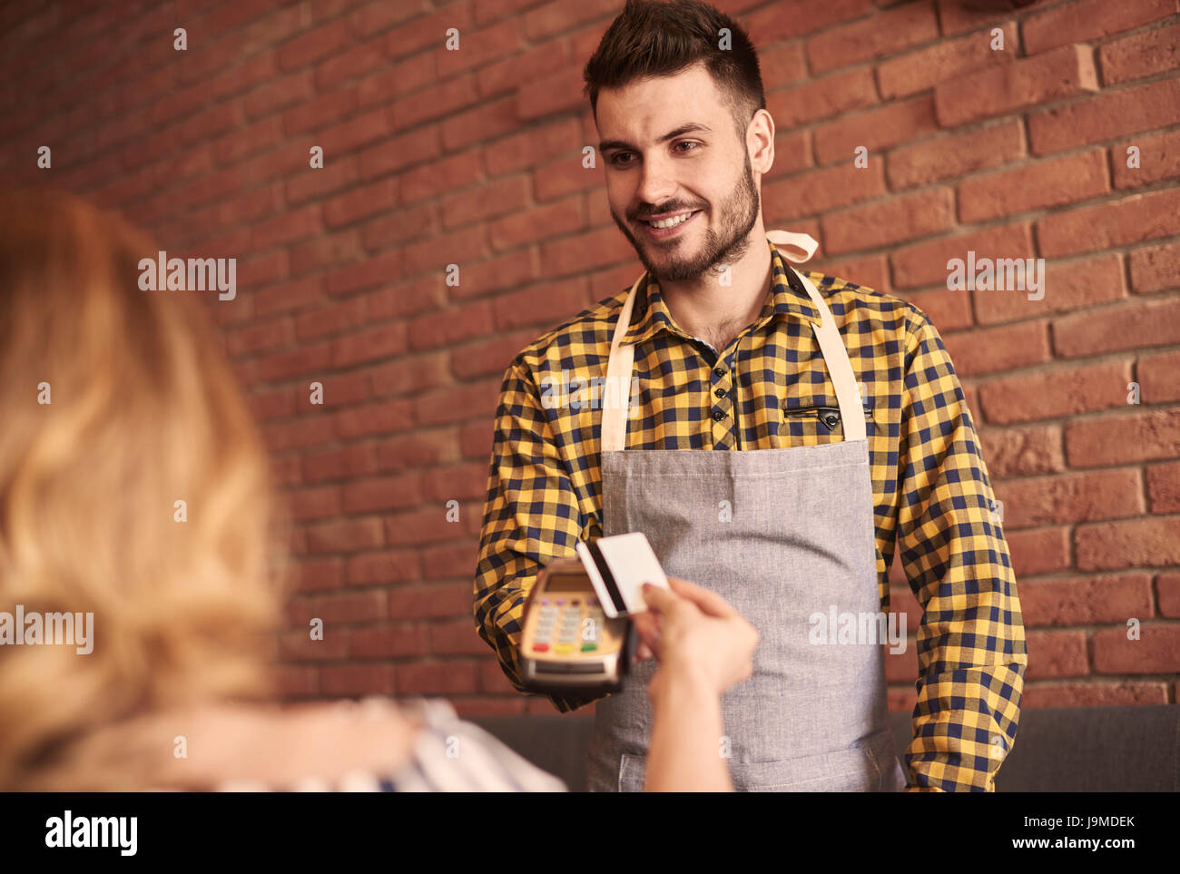 Kellner mit Kreditkartenleser warten auf Zahlung Stockfoto