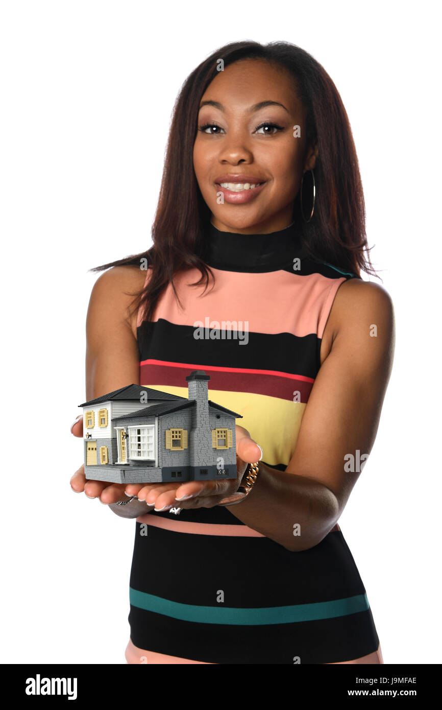 Afrikanische amerikanische Geschäftsfrau hält Miniaturhaus isoliert über weißen Hintergrund - selektiven Fokus auf Händen Stockfoto