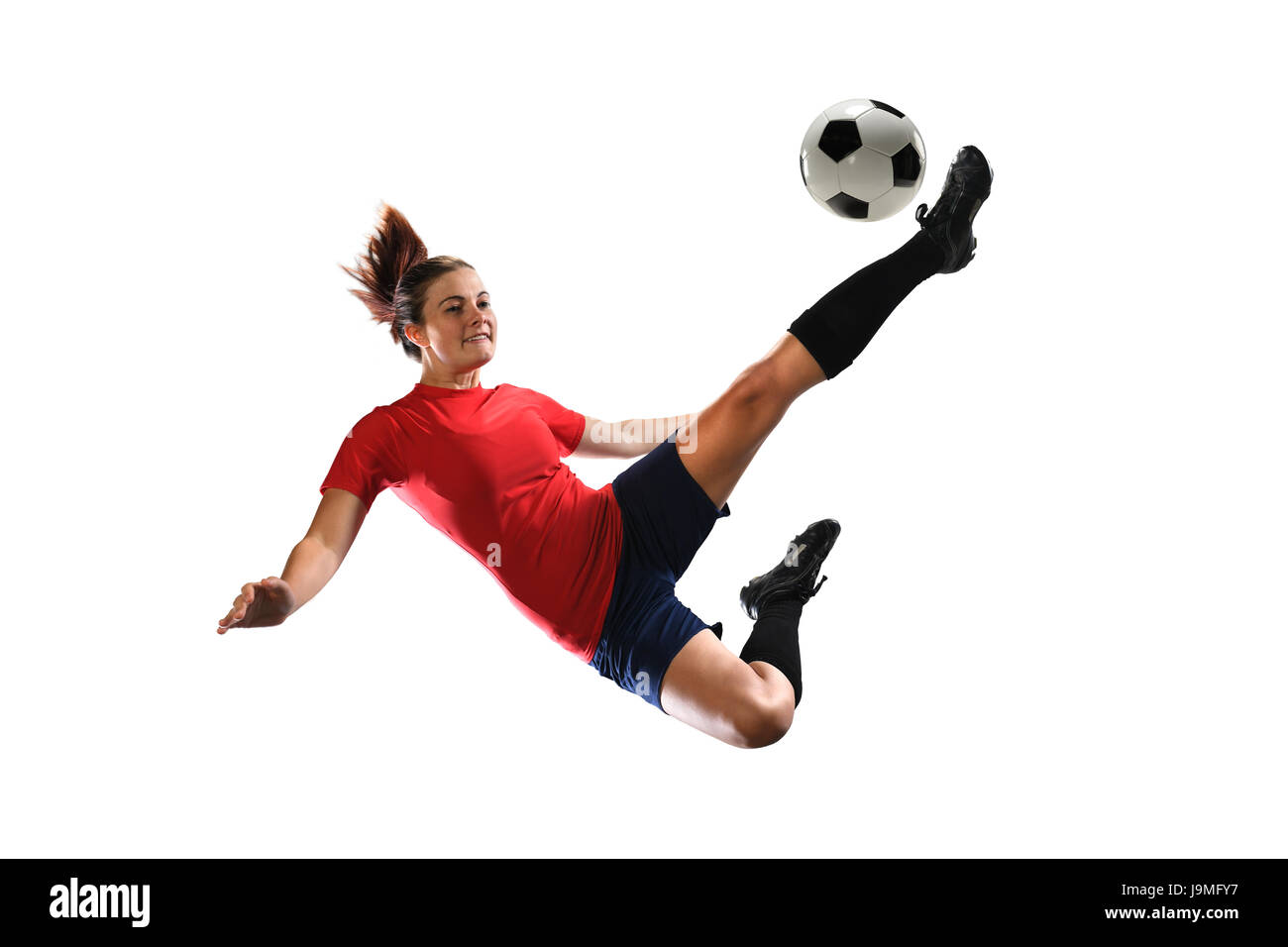 Weiblichen Fußballer treten Ball isoliert auf weißem Hintergrund Stockfoto