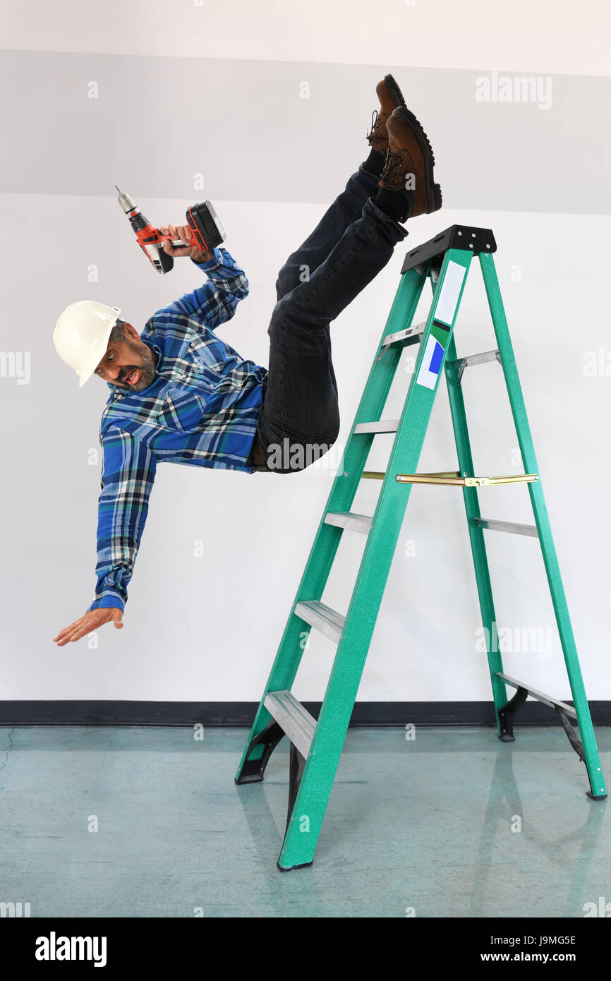 Arbeiter fällt von einer Leiter in Gebäude Stockfoto