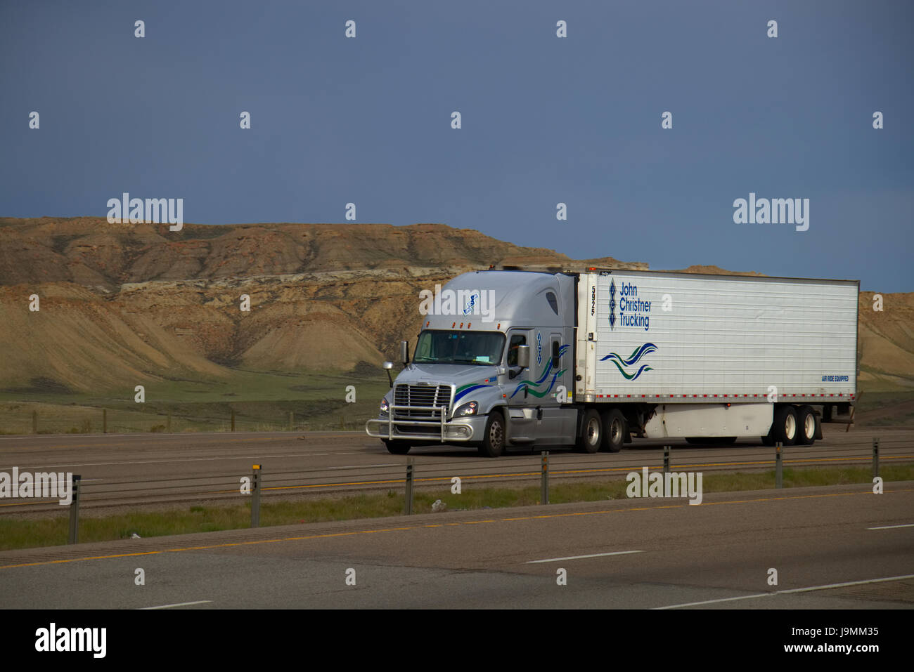 Ein semi-Silber oder grau Freightliner-Lkw zieht einem weißen "John Christner Trucking" Trailer entlang einer ländlichen uns Interstate. Stockfoto