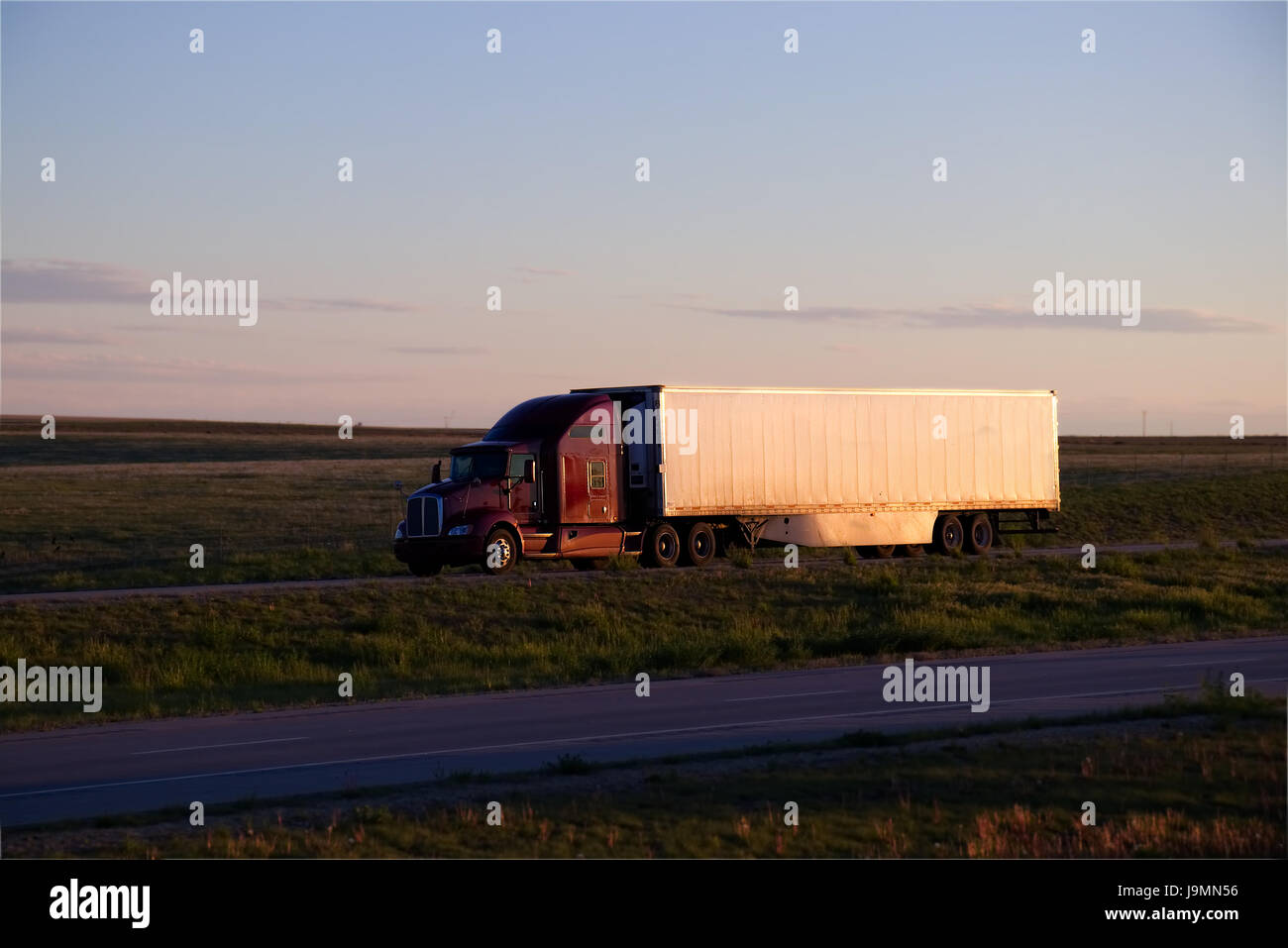 Große Lastwagen (LKW) reisen hinunter eine ländliche American Highway. Die meisten Markierungen und Marken wurden entfernt. Stockfoto